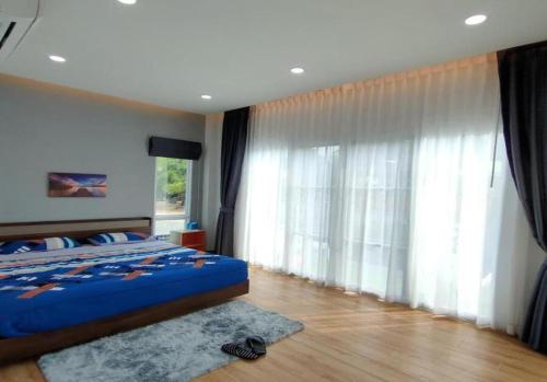 a bedroom with a bed and a large window at Pool Villa Udonthani in Udon Thani