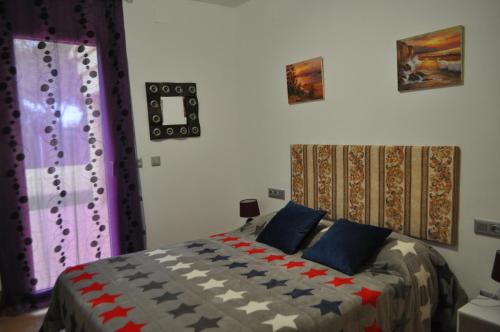 サン・ペレ・ペシュカドールにあるCasa Tatiのベッドルーム(カラフルなキルトのベッド付)