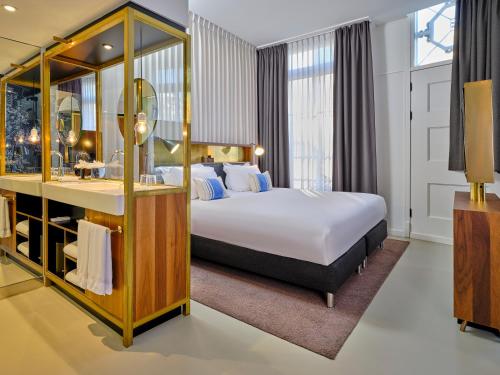 a hotel room with a bed and a desk at INK Hotel Amsterdam - MGallery Collection in Amsterdam