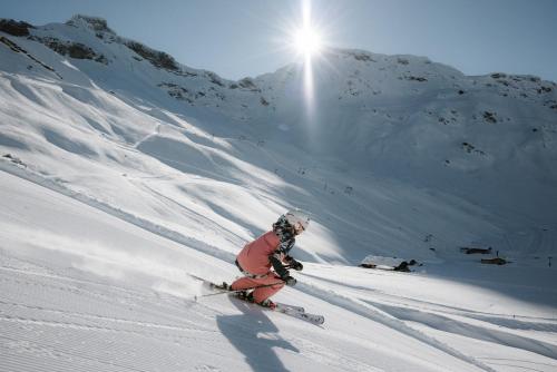 a person is skiing down a snow covered mountain at Berg- & Naturhotel Engstligenalp in Adelboden