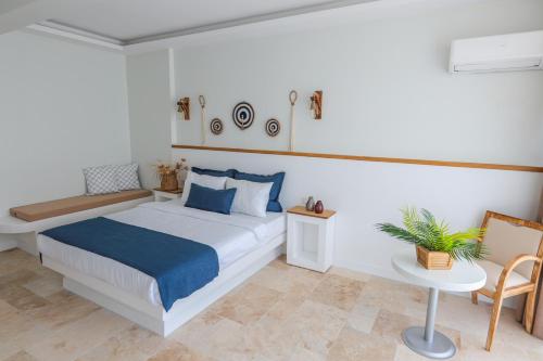 a bedroom with a bed and a table and a chair at Mavi Cam Hotel Ayvalik in Sefaçamlık