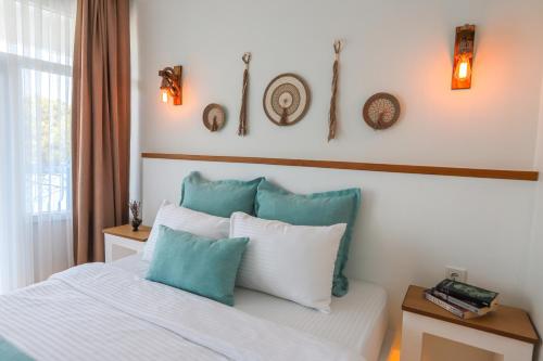 a bedroom with a bed with blue and white pillows at Mavi Cam Hotel Ayvalik in Sefaçamlık