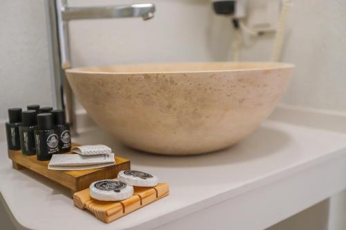 a bathroom counter with a sink and a bowl at Mavi Cam Hotel Ayvalik in Sefaçamlık