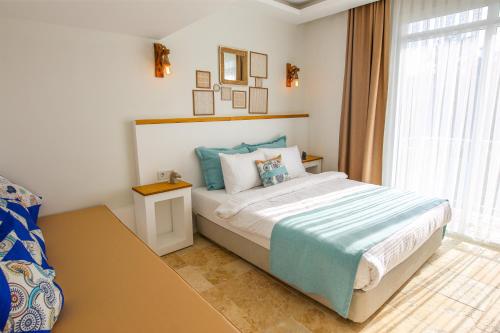 a bedroom with a large bed and a window at Mavi Cam Hotel Ayvalik in Sefaçamlık