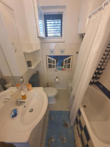 Apartment Marija Marina في مارينا: حمام مع حوض ومرحاض وحوض استحمام