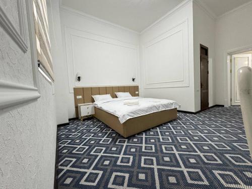 um quarto com uma cama no meio do quarto em ChashmaFam Hotel em Samarkand
