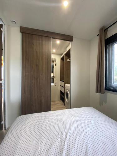 - une chambre avec un lit et une porte coulissante dans l'établissement Mobil home familial neuf de 2024 pour 8 personnes, à Valras-Plage