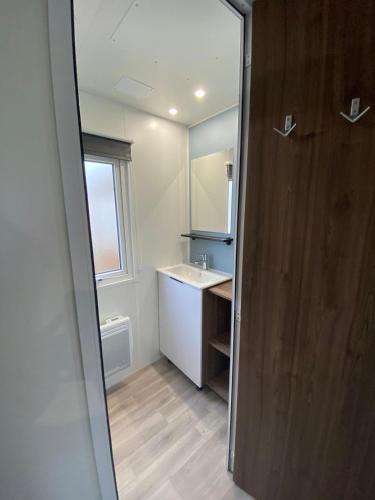 une salle de bain avec un lavabo et un miroir dans l'établissement Mobil home familial neuf de 2024 pour 8 personnes, à Valras-Plage