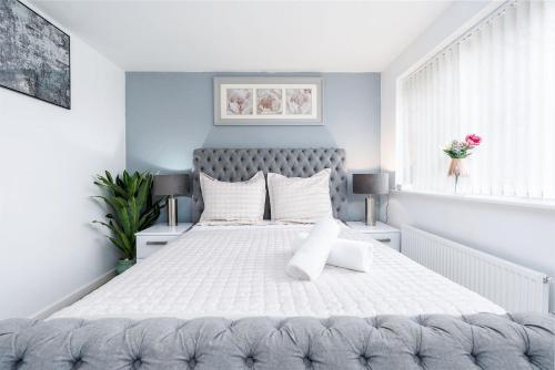 a bedroom with a large white bed with white pillows at Modern House with Parking and Garden in Doncaster