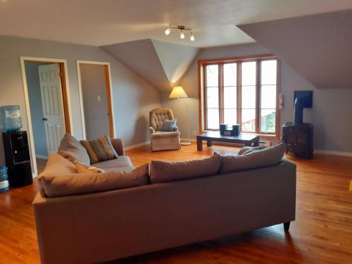 ein Wohnzimmer mit einem Sofa und einem Tisch in der Unterkunft Auberge Le P'tit Bonheur in Saint-Laurent-de-l'ile d'Orleans