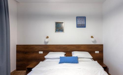 a bedroom with a bed with a blue pillow on it at Alliance Hotel in Tbilisi City