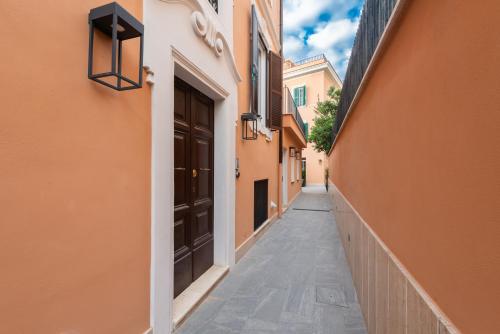 an alley with orange buildings and a black door at Major House - Luxury Apartments in Rome by Hostand in Rome