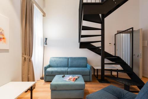 a living room with a blue couch and a staircase at Major House - Luxury Apartments in Rome by Hostand in Rome