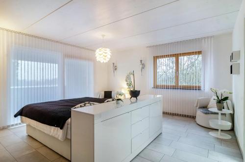 ein weißes Schlafzimmer mit einem Bett und einem Schreibtisch in der Unterkunft Turmalin in Überlingen