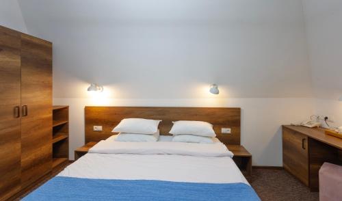 a bedroom with a large bed with two pillows at Alliance Hotel in Tbilisi City