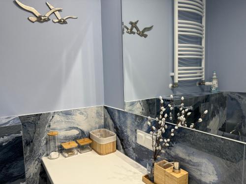 a bathroom with a sink and a bath tub at 4SUMMER Apartamenty White Blue Sauna & Fitness & Parking in Kołobrzeg