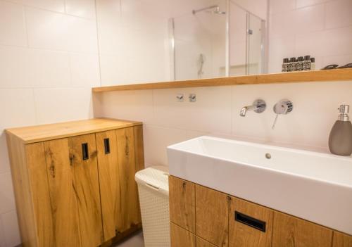 a bathroom with a white sink and a mirror at Apartview Bukowa III by Rent like home in Wisła