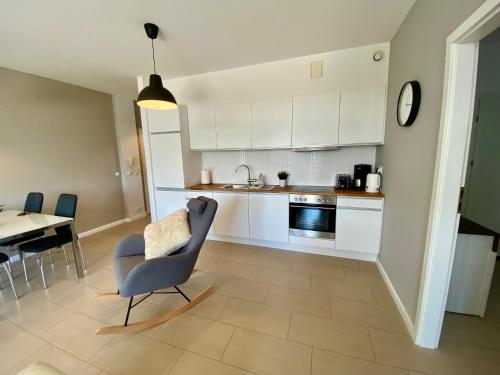 a kitchen with a table and a chair and a kitchen with white cabinets at Apartview Bukowa II by Rent like home in Wisła