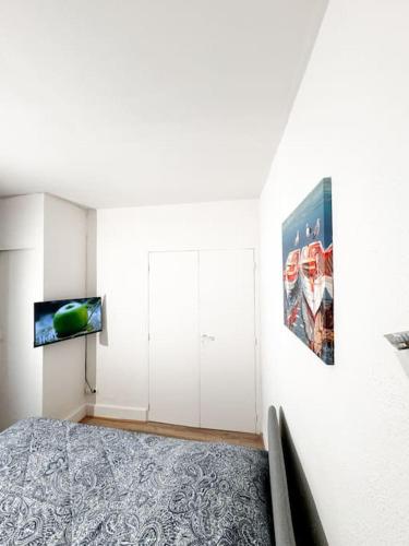 um quarto com uma cama e uma televisão na parede em Studio St Ursule R2 em Montpellier