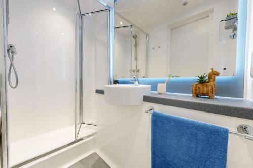 a white bathroom with a sink and a shower at Canvas Wembley in London in London