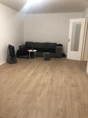 a living room with a black couch and a table at Appartement terrasse villepinte Parc des Expositions Rer b in Villepinte