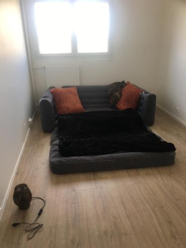 a couch sitting on the floor in a room at Appartement terrasse villepinte Parc des Expositions Rer b in Villepinte