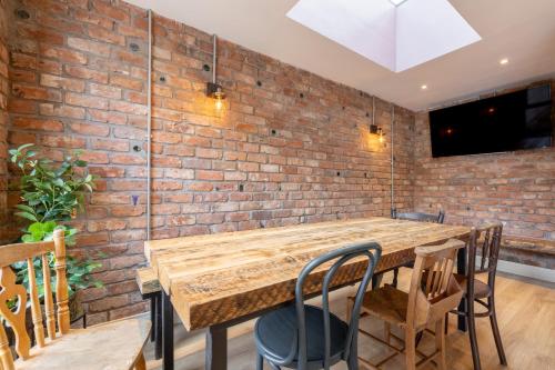 a brick wall in a room with a wooden table and chairs at Boutique Stays at 78 in Bangor