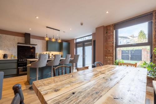 a kitchen and living room with a wooden table and chairs at Boutique Stays at 78 in Bangor
