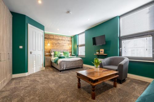 a bedroom with green walls and a bed and a table at Boutique Stays at 78 in Bangor