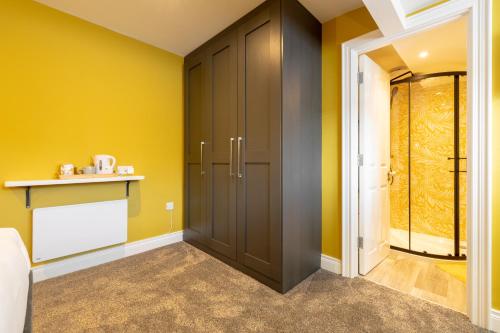 a room with a closet and yellow walls at Boutique Stays at 78 in Bangor