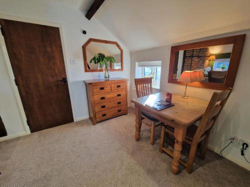 a dining room with a wooden table and a mirror at The Hayloft in Ivinghoe