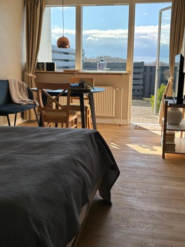 a bedroom with a bed and a table and a piano at Udsigten. in Ebeltoft