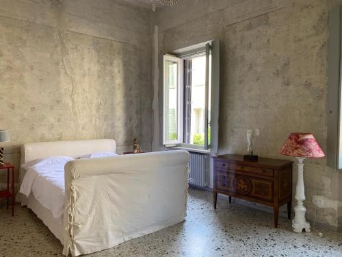 a bedroom with a bed and a table and a window at 7.Frecavalli Appartamento in Palazzo d'epoca in Crema