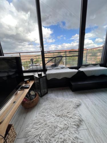 a room with a large window with a bed and a television at Zlatibor Wild in Zlatibor