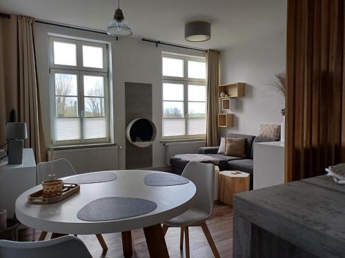 een woonkamer met een tafel en een bank bij Apartmenthaus Alte Börse in Carolinensiel