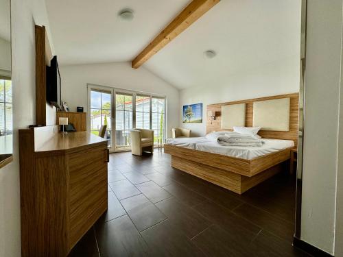 a bedroom with a bed and a desk with a television at Havellandhalle Resort in Seeburg