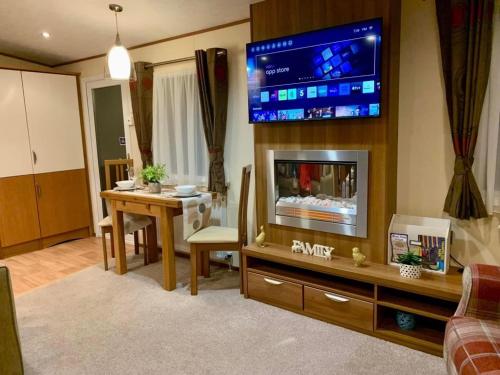 Lincolnshireにある29 Morningside at Southview in Skegness - Park Dean resortsのリビングルーム(暖炉の上にテレビ付)
