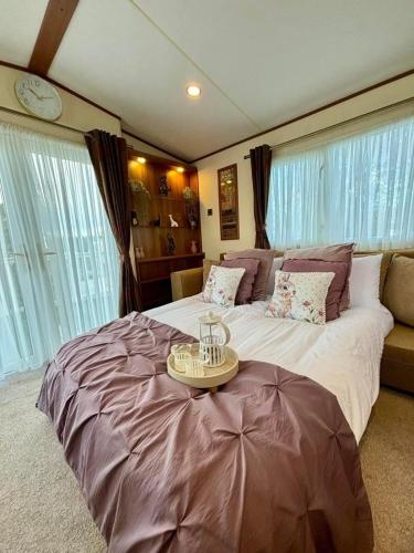 a large bedroom with a large bed with a table on it at 29 Morningside at Southview in Skegness - Park Dean resorts in Lincolnshire