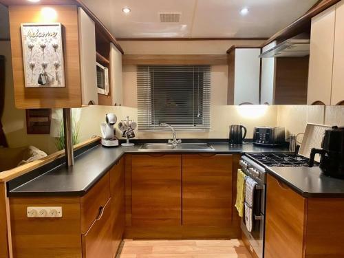 una cucina con lavandino e piano cottura forno superiore di 29 Morningside at Southview in Skegness - Park Dean resorts a Lincolnshire