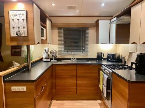a kitchen with a sink and a stove top oven at 29 Morningside at Southview in Skegness - Park Dean resorts in Lincolnshire