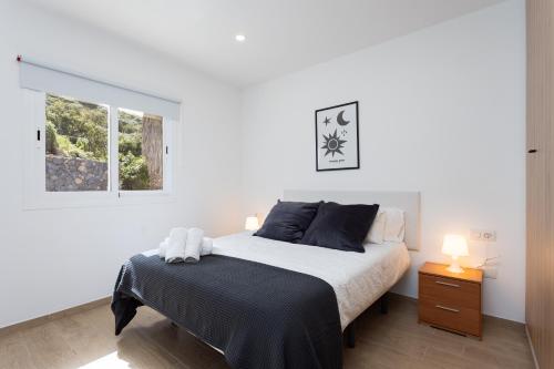 a white bedroom with a bed and a window at Nice Apartment in rural environment in La Orotava