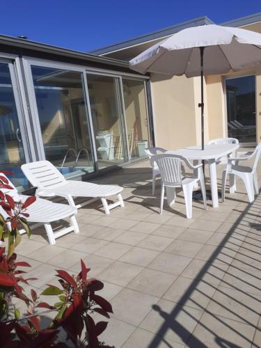 a patio with a table and chairs and an umbrella at GOLD HOUSE in Maranello
