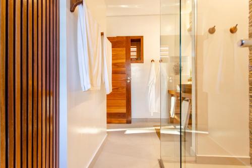 a bathroom with a glass shower and a sink at Aldeia Jericoacoara - Suites Privativas in Jericoacoara