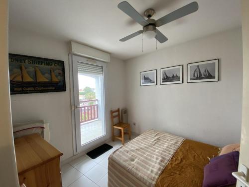 um quarto com uma cama e uma ventoinha de tecto em Appartement Canet-Plage, 3 pièces, 6 personnes - FR-1-750-51 em Canet-en-Roussillon
