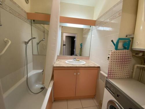 uma pequena casa de banho com um lavatório, um chuveiro e uma banheira. em Appartement Canet-Plage, 3 pièces, 6 personnes - FR-1-750-51 em Canet-en-Roussillon