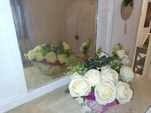 a bouquet of white roses in a vase at Gregorihouseroma in Rome