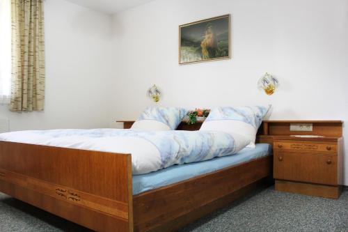 - une chambre avec un lit doté d'un cadre de lit en bois dans l'établissement Appartements Hanni, à Ehrwald