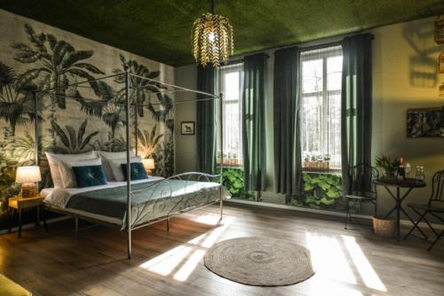 um quarto com uma cama de dossel numa sala verde em Apartament Palmiarnia przy Zamkowej w Wałbrzychu em Wałbrzych