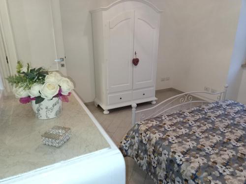 a bedroom with a bed and a dresser with flowers at Gregorihouseroma in Rome