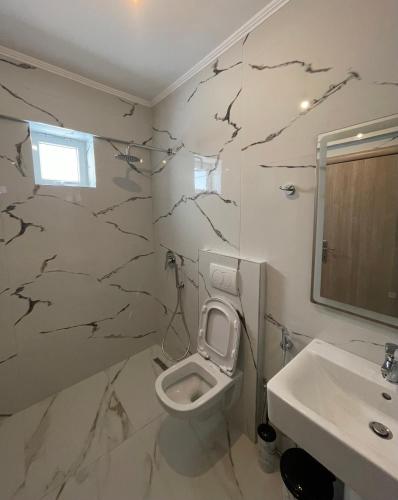 a bathroom with a toilet and a sink at Eveline Boutique Apartments in Sarandë